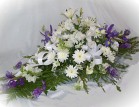 Send a sympathy arrangement containing white lilies, roses and other seasonal cut flowers - Click to enlarge
